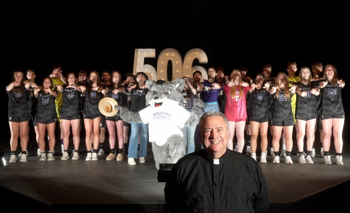 students adn wolf mascot stand with university president priest